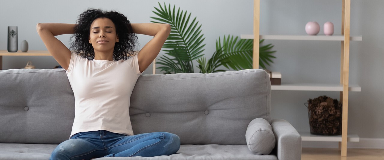 Mulher sentada no sofá relaxando em ambiente calmo